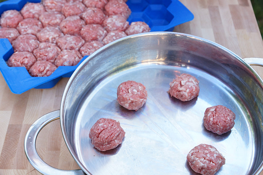 Meatball Master open with uncooked meatballs in pan